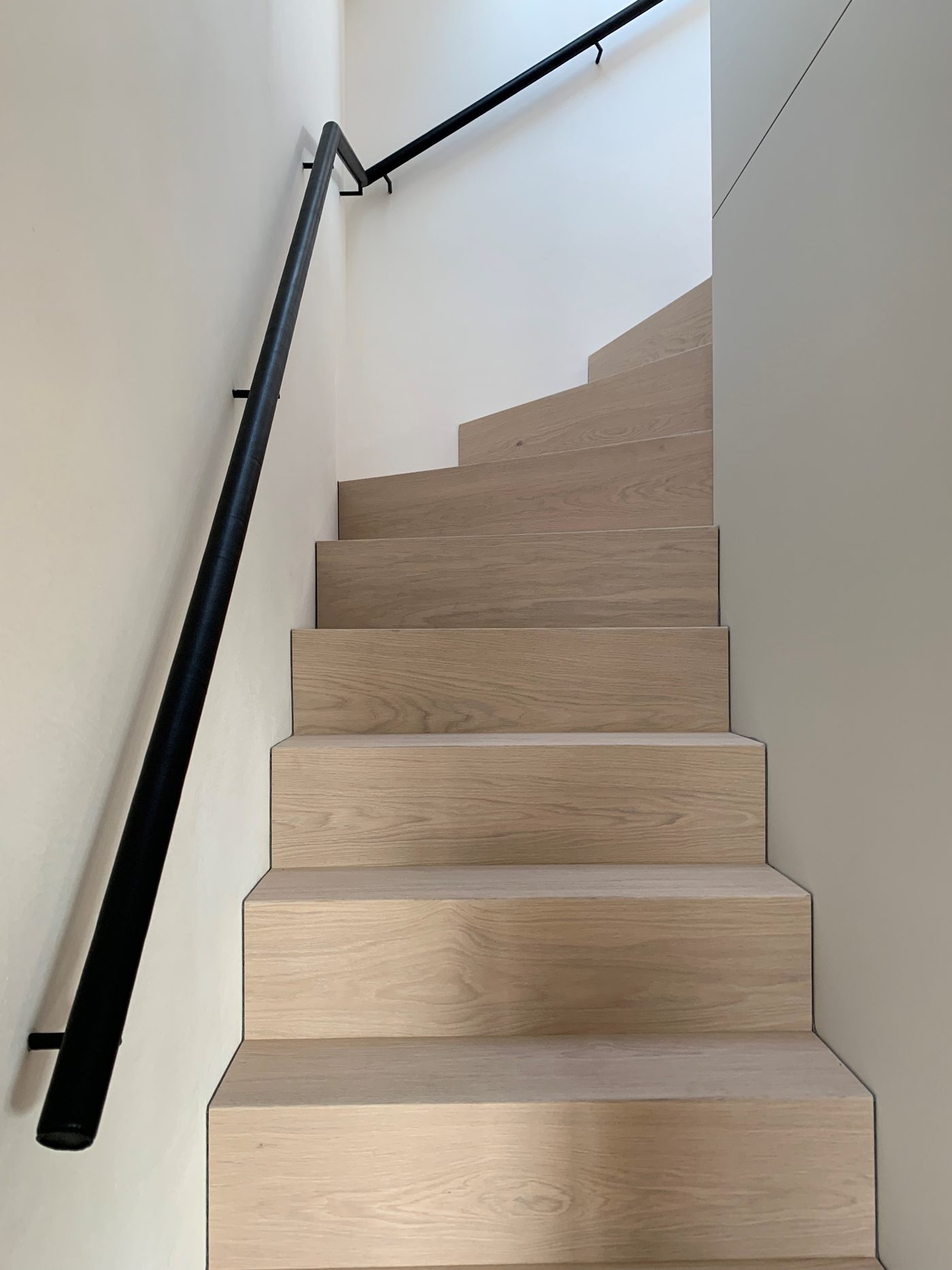 Lederbezogener Handlauf entlang einer Eichenholztreppe